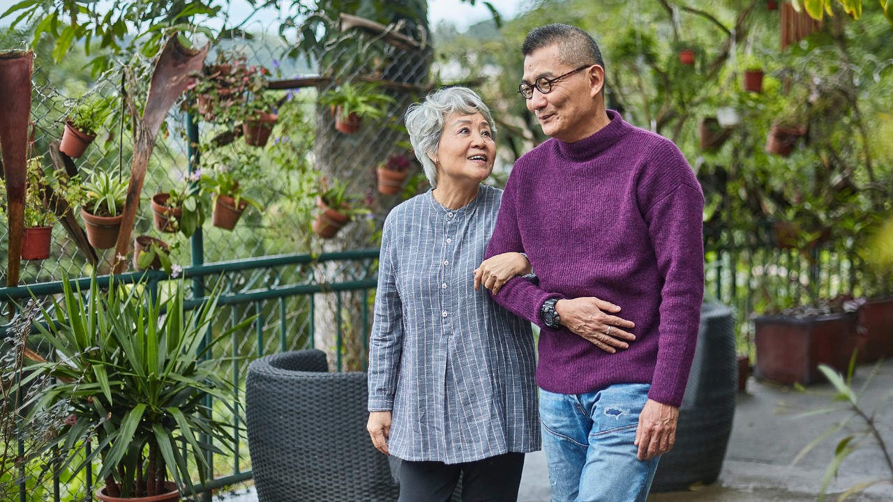 An old couple is walking in the garden; image used for "how to stay financially healthy" article.
