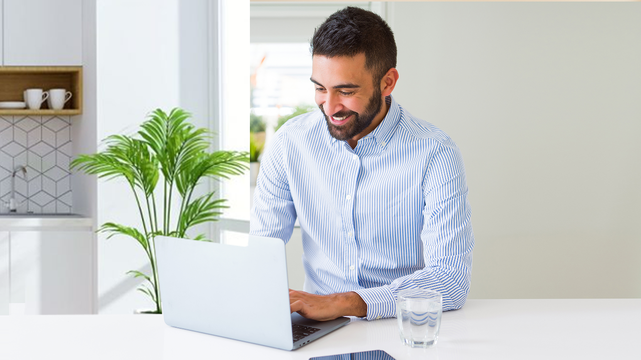 A man happily using laptop at home; image used for HSBC LK online banking page.